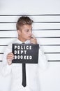 Caught in the act. Mug shot of a young man in a shirt and tie holding up a police department sign. Royalty Free Stock Photo