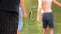 Caught fish dangles on a hook suspended on a fishing line. Fishing. Slow Motion