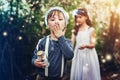 We caught so many fairies. Portrait of two little siblings catching fireflies in jars outside.