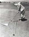 Caught between a rake and a gardening fork on the putting green