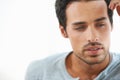 Caught up in contemplation. A cropped shot gorgeous young man deep in thought against a white background. Royalty Free Stock Photo