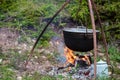 Cauldron or camping kettle over open fire outdoors Royalty Free Stock Photo