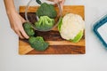 Cauliflower and broccoli close up on wooden cutting board directly from above on light grey background Royalty Free Stock Photo