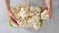 Cauliflower close-up on cutting board on kitchen table, woman hands Royalty Free Stock Photo