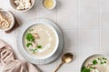 Cauliflower cream soup with pine nuts in a bowl on a white background