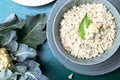 Cauliflower rice in bowl on green background. Top view. Overhead. Copy space. Shredded cauliflower. Royalty Free Stock Photo