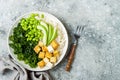 Cauliflower rice Buddha bowl with massaged kale, tofu, avocado and edamame beans. Vegan poke bowl.