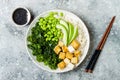 Cauliflower rice Buddha bowl with massaged kale, tofu, avocado and edamame beans. Vegan poke bowl.