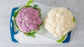 Cauliflower, white and purple, close-up on a cutting board, light gray stone background, flat lay Royalty Free Stock Photo