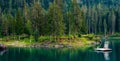 Caumasee mountain lake in the Swiss Alps floating raft sunny summer time clear turquoise water pine tree forest in the background Royalty Free Stock Photo