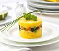 Causa rellena served on a plate with parsley and chives