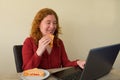 Causasian woman enjoying breakfast or lunch while working or learning at home