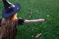 Causcasian blond girl with long hair in halloween witch costume sitting on the grass Royalty Free Stock Photo