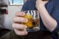 a causcasian male hand holding an old fashioned alcoholic drink inside of a bar and restaurant Royalty Free Stock Photo