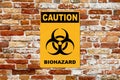 Caution - Biohazard sign on a brick wall