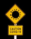 Caution Covid-19 written on a yellow warning danger roadsign. Coronavirus covid pandemic concept