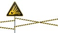 Caution - danger Warning sign safety. Explosive substances. yellow triangle with black image. sign on the pole and protecting ribb Royalty Free Stock Photo