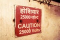 Caution 25000 high voltage safety warning sign board in red color and the instructions to communicate at work to say keep away