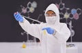 Caution in the lab. A young scientist in protective clothing using a pipet in her lab.