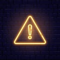 Caution neon sign on brick wall. Glowing gold exclamation mark icon. Warning symbol. Attention button. Realistic night