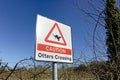 A Caution Otters Crossing Sign at Smallbrook Meadows, Warminster, UK Royalty Free Stock Photo