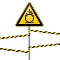 Caution oxidizer. Safety sign. Safety at work. Yellow triangle with black image, metal pillar, protective red tapes