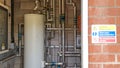 A swimming pool plant room with blurred warning sign outside on the wall