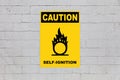 Caution, Self ignition - Sign on a cinder block wall Royalty Free Stock Photo