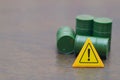Caution Sign with Green Barrels Symbolizing Hazardous Waste and Environmental Risk Royalty Free Stock Photo