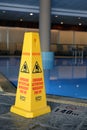 Caution signs warning about slippery and wet floor in multiple languages
