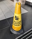 caution slippery surface yellow cone