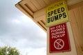 Caution Speed Bumps No Cell Phones During Pickup Sign