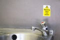 Caution very hot water sign above taps no thermostatic temperature control in public toilets not drinking water