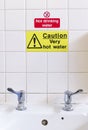 Caution very hot water sign above taps no thermostatic temperature control in public toilets not drinking water