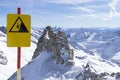 Caution warning sign in mountains ski resort - carefully down the cliff. Alpine Alps mountain landscape at Tirol, Top of