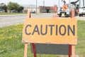 caution word caption text sandwich board wooden sign next to sidewalk and grass. p