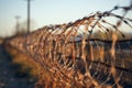 Cautionary barbed wire on fence, signaling restricted access, secure boundary Royalty Free Stock Photo