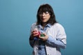 Cautious professional chemistry laboratory worker on blue background having Erlenmeyer glass jars. Royalty Free Stock Photo