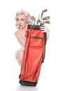 Cautious retro girl peeking out from behind red golf bag, isolated on white with space for text Royalty Free Stock Photo