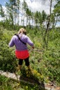 Cautious woman tries to hike in the wilderness wearing the wrong type of clothing for the activity Royalty Free Stock Photo