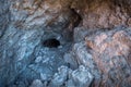 Cave entrance, dark tunnel leading under a mountain