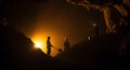 Cave Explorers Silhouetted Inside Dark Cave with Headlamps and Sunlight Backlighting Royalty Free Stock Photo