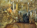 Cave with hanging stalactites and stalagmites on rocks, Barbados Island.