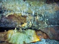Cave with hanging stalactites and stalagmites on rocks, Barbados Island