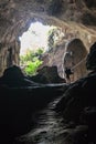 Cave with man standing on a rock in front of the entrance Royalty Free Stock Photo