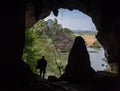 Cave with man standing on a rock in front of the entrance Royalty Free Stock Photo