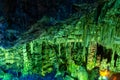 Cave rock formations are stalactites and stalagmites in colorful light. The miracle of the formation of stalagmites in the dark Royalty Free Stock Photo