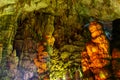 Cave rock formations are stalactites and stalagmites in colorful light. The miracle of the formation of stalagmites in the dark