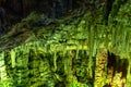 Cave rock formations are stalactites and stalagmites in colorful light. The miracle of the formation of stalagmites in the dark