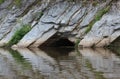A cave in the rocks, flooded with water. Stone rocks and their reflection, Belaya river, Russia, South Ural. Traveling on the Royalty Free Stock Photo